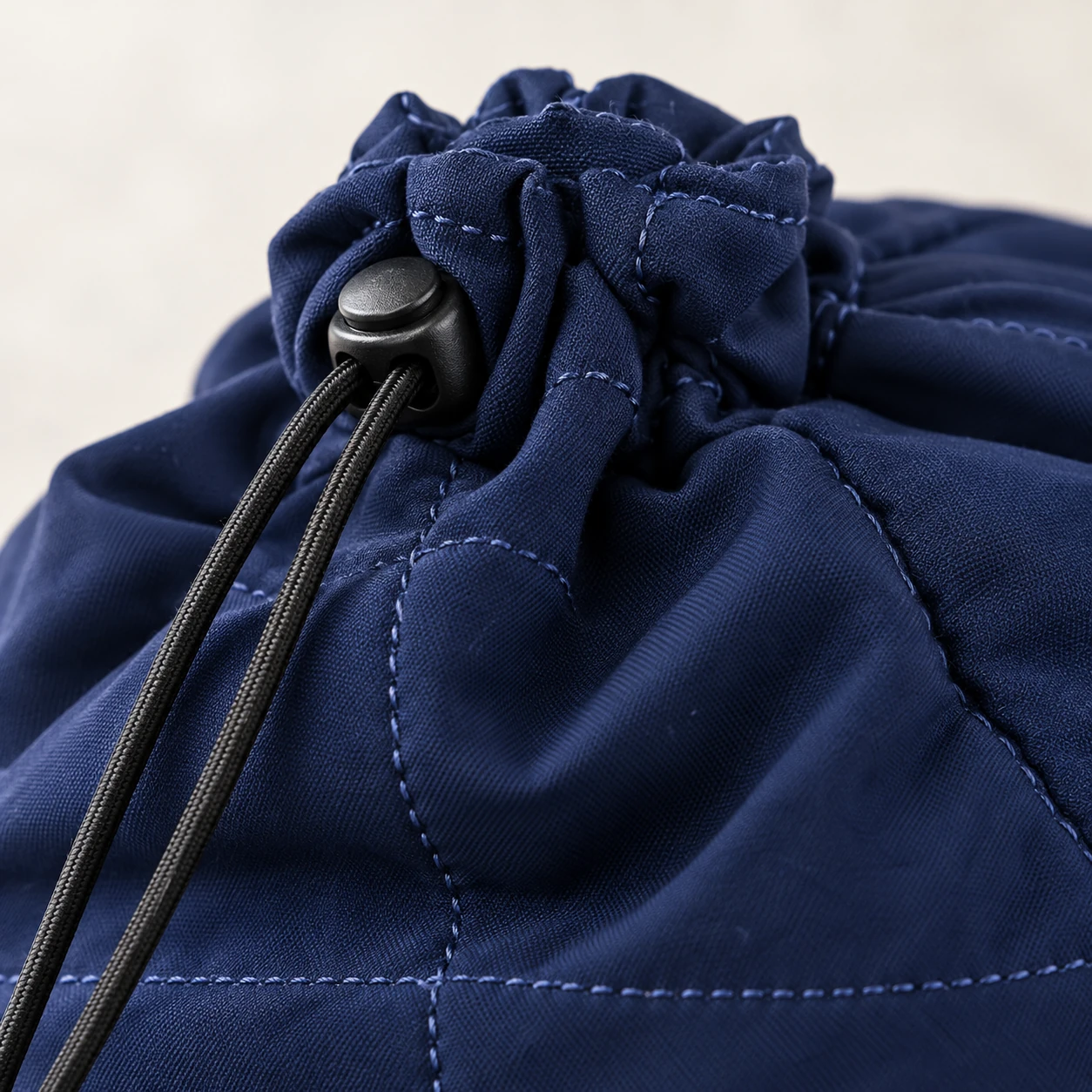 Close view of the drawstring toggle and stitching on a navy head wrap