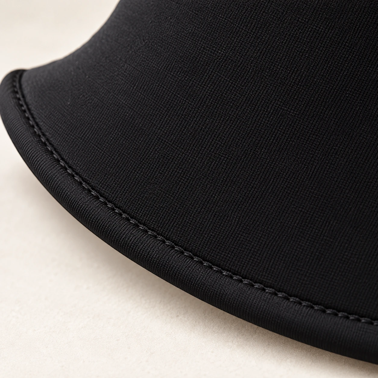 Close view of the textile and curved bound edge on a black neck collar