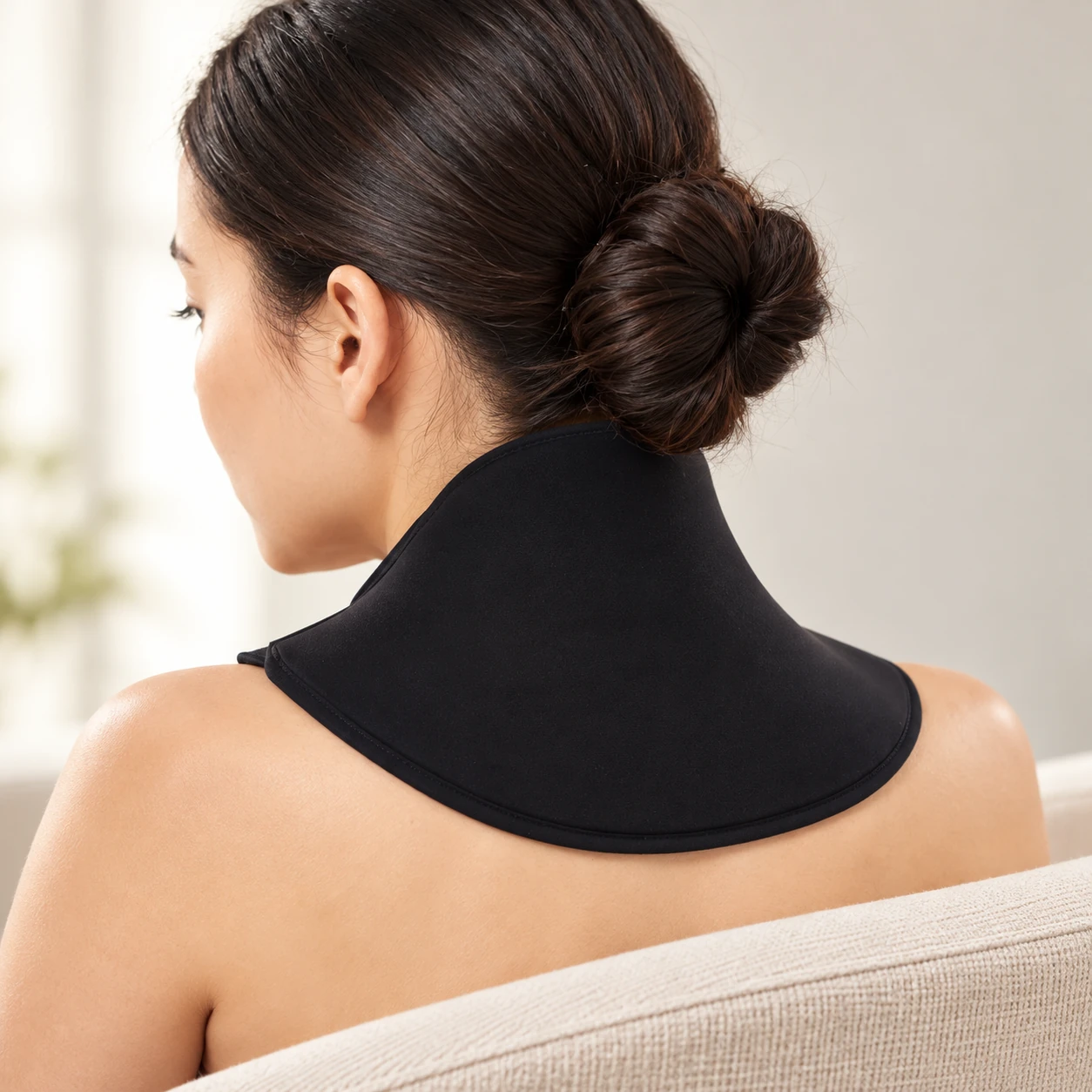 Adult wearing a black flared neck collar viewed from behind