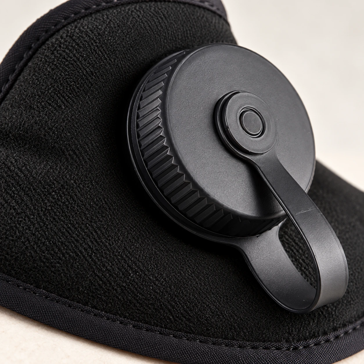 Close view of the neck-wrap cap, tether and surrounding fabric