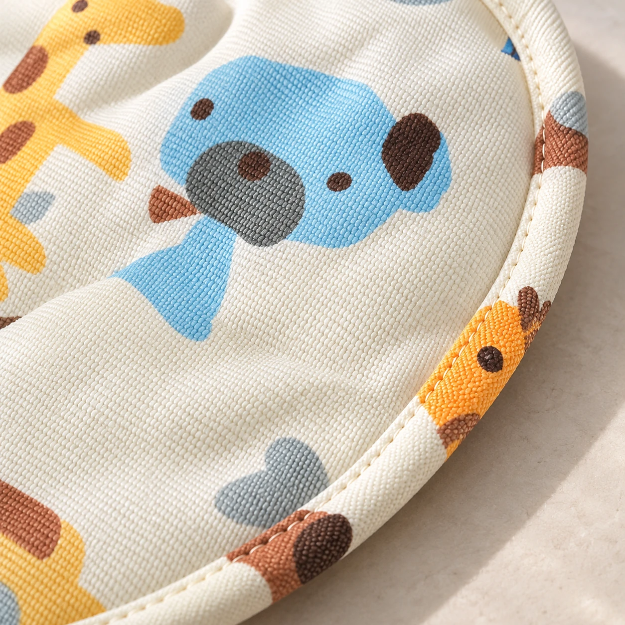 Close view of the animal-print fabric and stitched binding edge