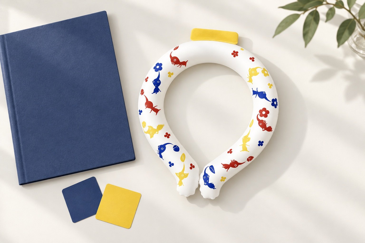 White open-front neck ring with multicolor fish and flower artwork beside navy and yellow color cards